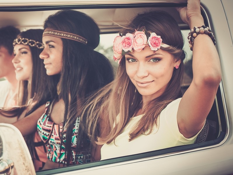 Multi-ethnic hippie friends in a minivan on a road trip